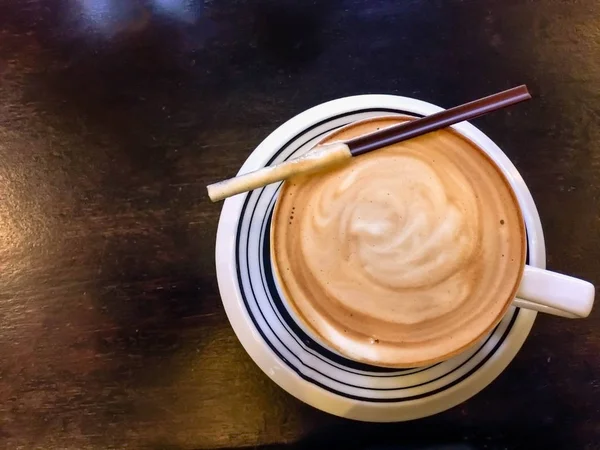 Cappuccino dan air di atas meja dengan segelas air — Stok Foto