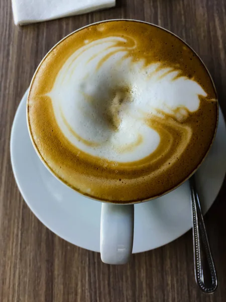 Cappuccino panas close up di atas meja dengan sendok — Stok Foto