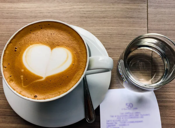 Cappuccino panas close up di atas meja dengan sendok — Stok Foto