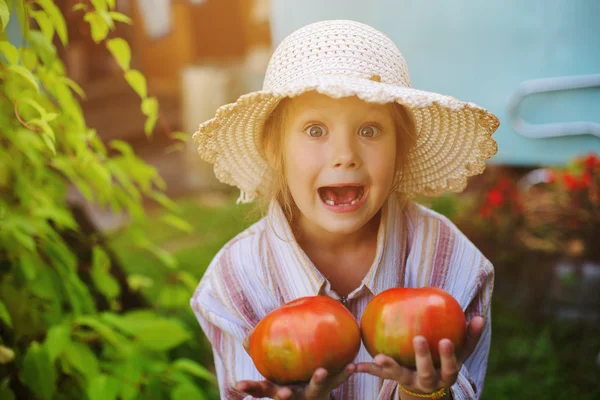 Pequena menina feliz com tomate — Fotografia de Stock