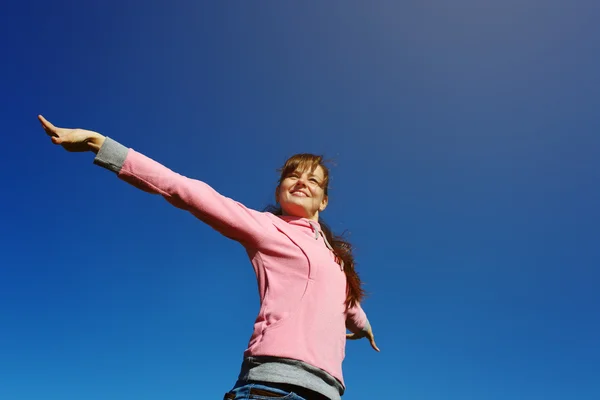 Beautiful young woman against the blue sky. — Stock Photo, Image