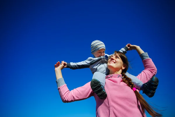 Mutter mit dem Sohn gegen den blauen Himmel — Stockfoto