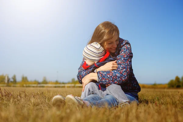 Feliz joven hermosa Mather con el bebé en la naturaleza al aire libre —  Fotos de Stock