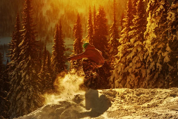 Snowboarder sautant contre le coucher du soleil — Photo