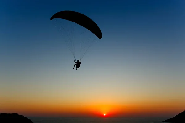 Paraglider silhouette against the background of the sunset sky — Stock Photo, Image