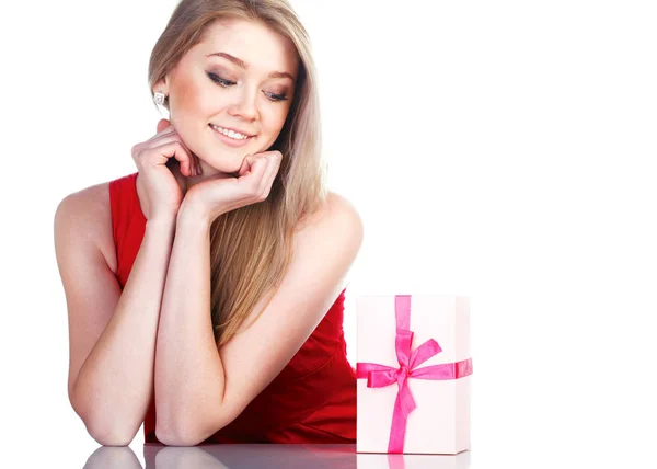 Schöne Mädchen in einem roten Kleid mit einem Geschenk. — Stockfoto