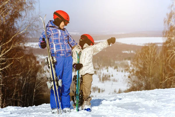 Mamá y su hija, en el equipo de esquí jugar con la nieve en —  Fotos de Stock