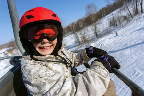 Menina esquiador em um capacete vermelho e óculos — Fotografia de Stock