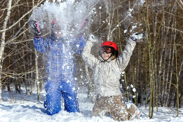 Мама и дочь, в лыжном снаряжении играют со снегом — стоковое фото
