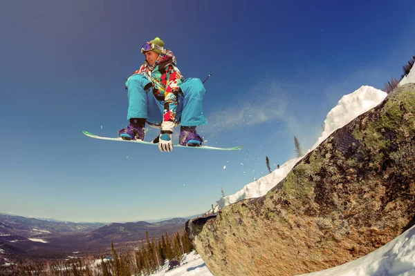 Snowboarder jumping από το εφαλτήριο ενάντια στον ουρανό — Φωτογραφία Αρχείου