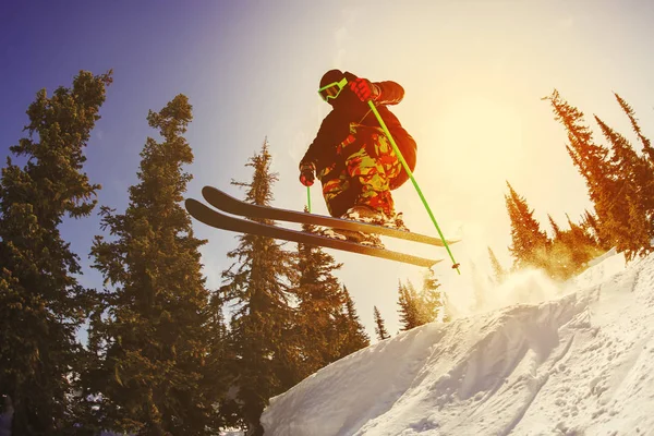 De skiër springt uit een springplank in het skigebied. — Stockfoto