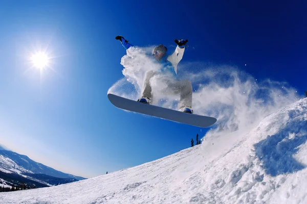 Snowboarder pulando do trampolim contra o céu — Fotografia de Stock