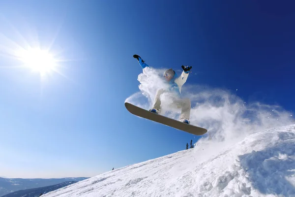 Snowboarder jumping from the springboard against the sky — Stock Photo, Image