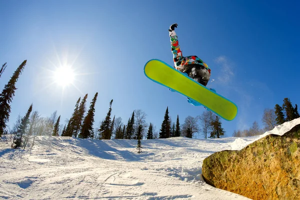 Gökyüzüne karşı sıçrama tahtası üzerinden atlama snowboarder — Stok fotoğraf