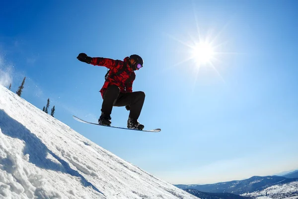 Snowboarder pulando do trampolim contra o céu — Fotografia de Stock