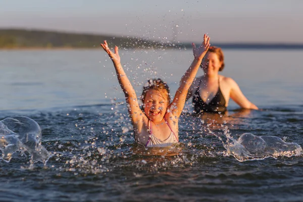 A little girl and her mother  in the water of the sea. — Stock Photo, Image