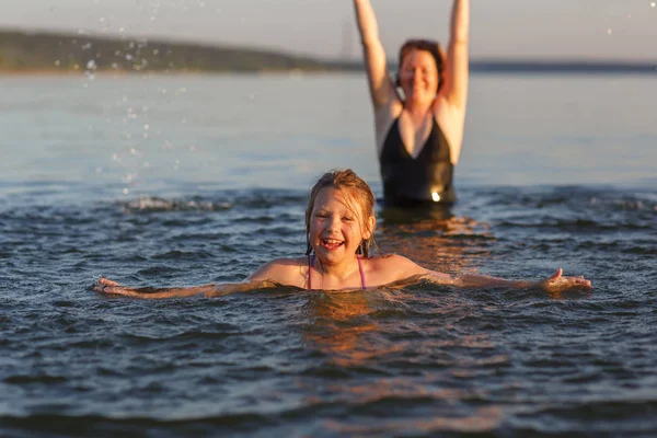 A little girl and her mother  in the water of the sea. — Stock Photo, Image