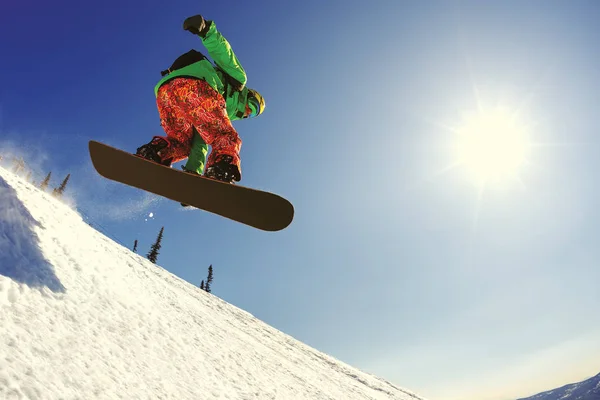 Snowboarder pulando do trampolim contra o céu — Fotografia de Stock