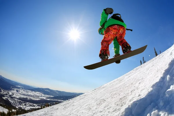 Snowboarder springen van de plank tegen de hemel — Stockfoto
