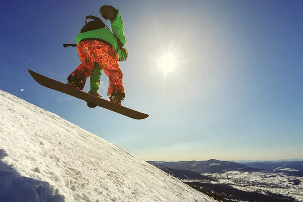 Gökyüzüne karşı sıçrama tahtası üzerinden atlama snowboarder — Stok fotoğraf