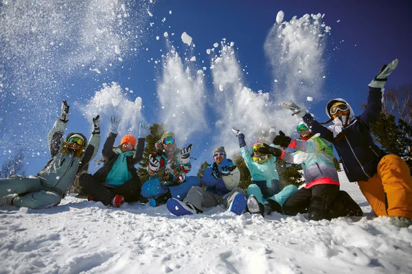 Un groupe d'amis de skieurs et snowboarders s'amuse à jeter de la neige — Photo