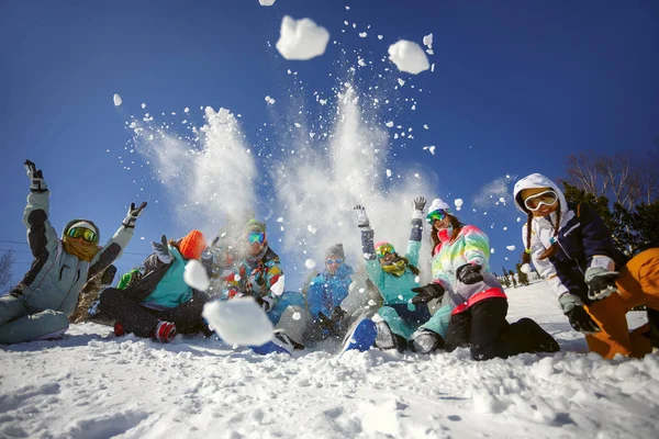 Группа друзей лыжников и сноубордистов веселятся, бросая снег — стоковое фото
