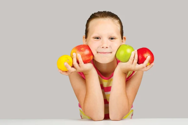 Весела маленька дівчинка з яблуками і лимоном пози пози пози пози позитивно в — стокове фото