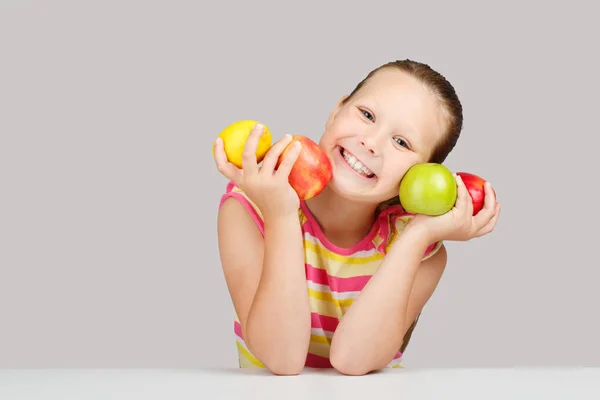 Niña alegre con manzanas y limón posa positivamente en s — Foto de Stock