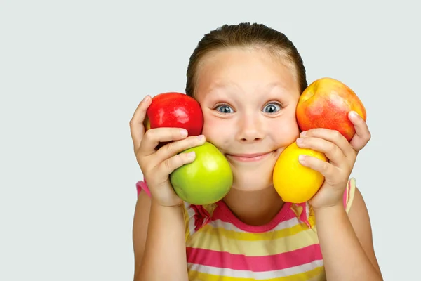 Fröhliches kleines Mädchen mit Äpfeln und Zitrone posiert positiv in s — Stockfoto