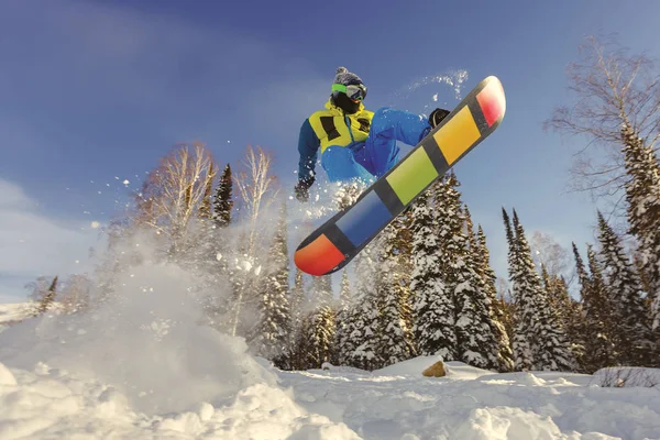 Snowboarder pulando do trampolim contra o céu — Fotografia de Stock