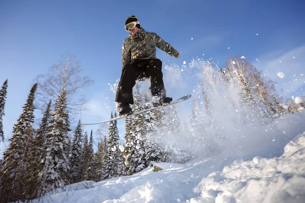 Gökyüzüne karşı sıçrama tahtası üzerinden atlama snowboarder — Stok fotoğraf