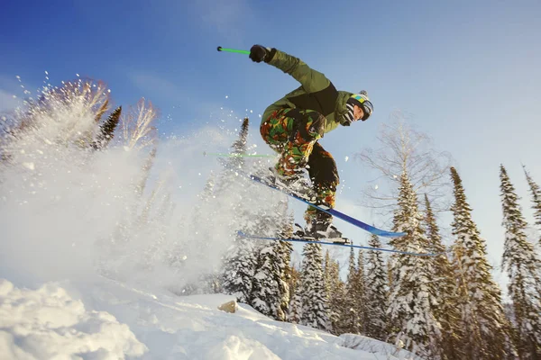 Der Skifahrer springt von einem Sprungbrett im Skigebiet. — Stockfoto