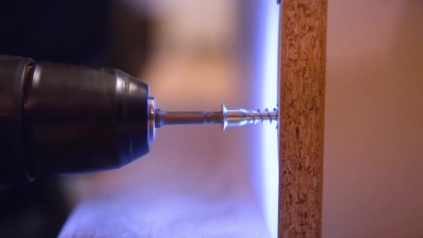 Destornillador atornillar un tornillo en un material de madera — Vídeos de Stock
