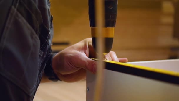 Чоловік працівник свердлить матеріал деревини — стокове відео