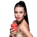 Frau mit roter Einweg-Tasse Kaffee