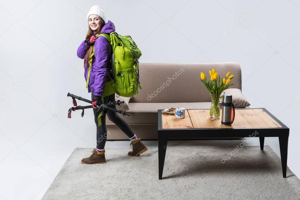 beautiful sportswoman in warm clothing with backpack and hiking equipment ready to travel