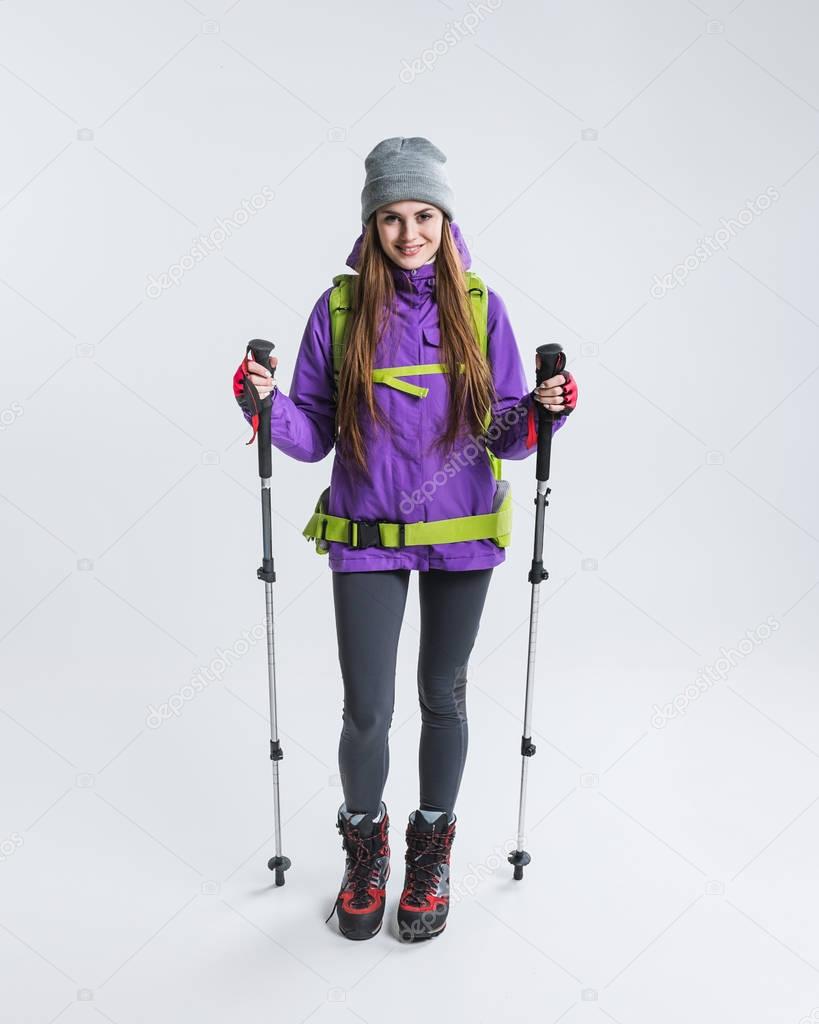 female traveler with backpack and hiking equipment, isolated on grey