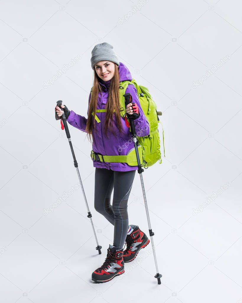 happy hiker with backpack and hiking equipment, isolated on grey