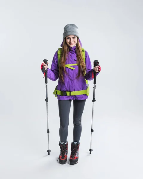 Viaggiatore femminile con zaino e attrezzatura da trekking, isolato su grigio — Foto stock