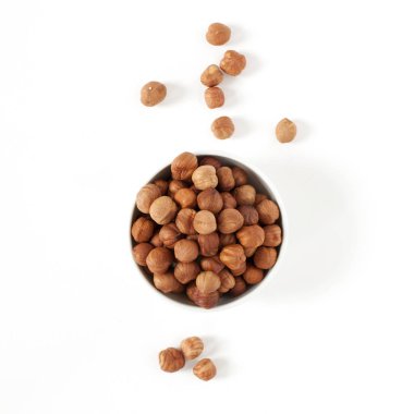 Beyaz bir arka plan üzerine bir kase saflaştırılmış fındık