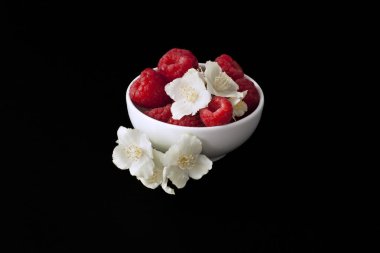 siyah arka plan üzerine bir kase taze frambuaz