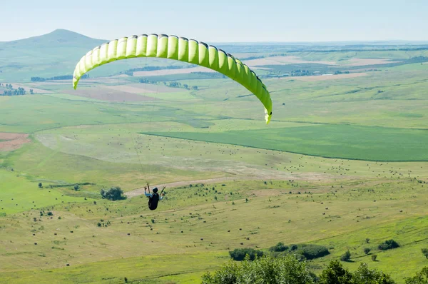 Yamaç paraşütü pilot uçan alanlar mavi gökyüzü ve dağ manzara karşı