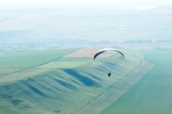 Yamaçparaşütü pilot tarlalara paraglider üzerinde uçar.