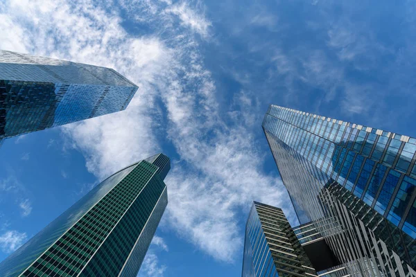 Modern tall office buildings. Skyscrapers in the business district of Moscow City. Business center. Sky and clouds are reflected in the windows. Low angle view.