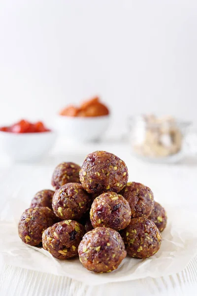 Energy balls with dried fruits and pistachios. Healthy vegan food. Raw diet. Good nutrition concept. White wooden background. Copyspace from above.