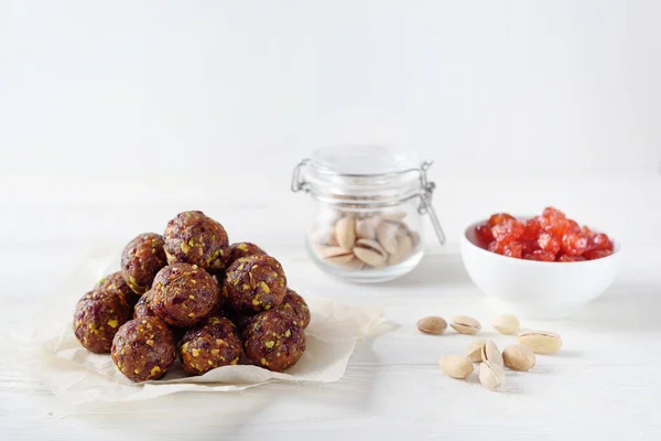 Kurutulmuş meyve ve fıstıklı enerji topları. Sağlıklı vegan ve çiğ gıda diyeti. İyi beslenme konsepti. Beyaz ahşap arka plan. Yukarıdan Kopyalama Uzayı.