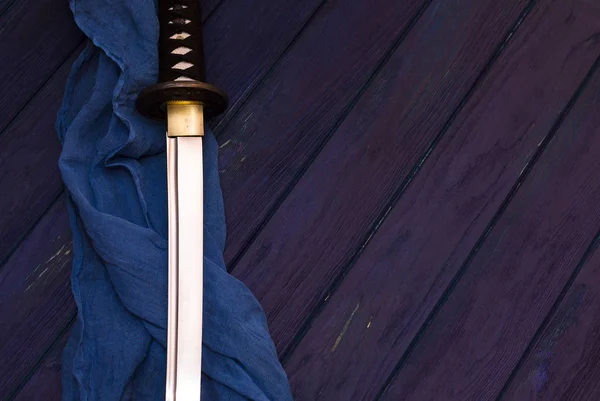 Espada katana japón sobre el fondo de madera con el chal azul —  Fotos de Stock