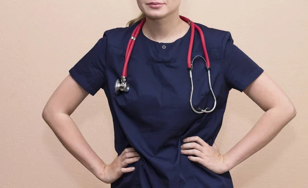 Real female doctor with the red stethoscope in medical uniform