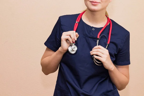 Real female doctor with the red stethoscope in medical uniform