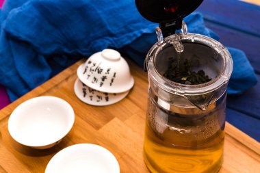 Cam çaydanlık mavi ahşap arka plan WIT Tarih yeşil bitki çayı